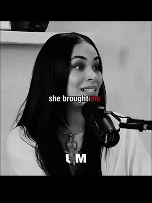 A black and white image of a woman with long black hair, looking astounded while holding a microphone. Text is overlaid on the image, highlighting a specific moment.