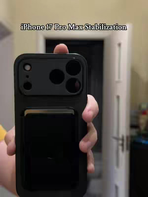 The cover image shows a person holding a black iPhone case with a camera cutout design centered and prominent. The hand is holding the phone towards the camera appearing to be demonstrating the phone's features. Behind the hand, the image shows a room setting with the wall and door visible.