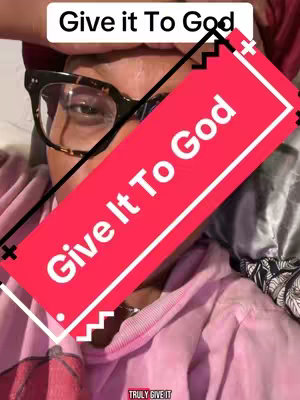 The cover image shows a person with dark-rimmed glasses, appearing to be in a selfie-style video. Text overlays read, 'Give it To God' in both upper text and a highlighted red angled rectangle. The person is wearing a pink hoodie, and the background is soft, possibly fabric, in muted tones, creating an intimate ambiance.