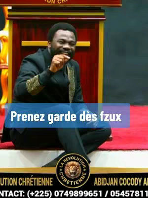 A man in a suit sits in front of a wooden podium with a colorful background. A text overlay is placed on a blue box that reads, in French, 'Prenez garde des fzux.' A circular logo is visible at the bottom with the words 'LA REVOLUTION CHRETIENNE' encircling a golden emblem.