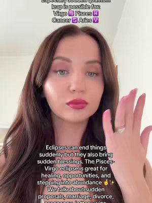 The cover image features a woman in a selfie-style shot. She has long, dark brown hair and is wearing makeup with red lipstick. She's holding up her right hand, displaying a ring on her finger. Text overlays with information about astrological predictions are present on the image.