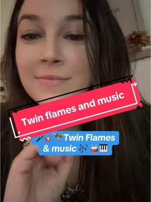 A young woman with long dark hair and a nose ring is shown in a medium close-up, with a focus on her face. She is smiling gently, and the lighting appears to be soft. Overlaid on the image are several text elements in colored boxes: a red rectangle with the text "Twin flames and music" in white, a blue rectangle with the text "Twin Flames & music" and musical instrument icons. The background is out-of-focus, making the woman and the overlaid text the primary focus.