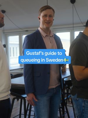 A man in a blazer is standing, smiling, with a light blue text overlay that says 'Gustaf's guide to queueing in Sweden', placed over a light blue background with a white border, and the Swedish flag to the right. He is positioned in front of other people. The background is a room with large windows.
