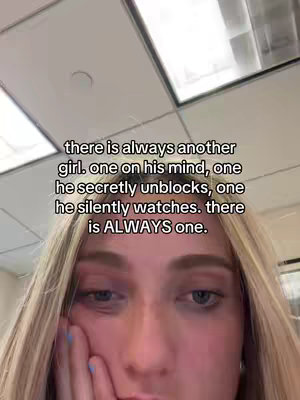 The cover image captures a close-up of a young woman with blonde hair staring at the camera with a slightly melancholic expression. Above her, overlapping text in a simple white font conveys a message about infidelity, framed against what appears to be an office ceiling.
