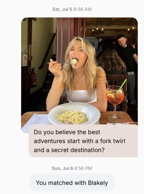 A woman is shown in a restaurant setting, holding a fork with spaghetti in her mouth. She's wearing a white top and has blonde hair. In the background, there's a restaurant interior with other diners and a bar area. A text bubble appears on the image with text, and another text box at the image bottom referencing a date.
