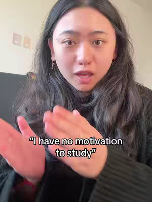 A young woman with dark hair is looking at the camera with an open mouth, seemingly speaking. Overlayed text reads, "I have no motivation to study".