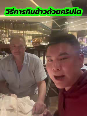A video featuring a man in a red hoodie, possibly a creator, speaking directly into the camera with another man visible in the background. The background suggests a restaurant setting with decorative lighting.