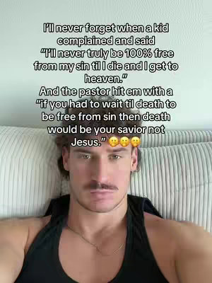 A man in a black tank top is seated indoors on a couch. A quote is added to the image as text.