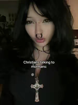A close-up shot features a young woman with black hair and multiple facial piercings, set against a blurred background. She wears a black top and a crucifix pendant, with overlaying text. This shot focuses on the face and a religious accessory.
