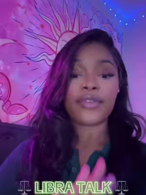A young woman with long dark hair is centered in the frame, looking towards the camera with a slight smile. She is in a room decorated with pink and purple lighting. Behind her, a tapestry with a sun design. Below her, a text overlay reads "LIBRA TALK" in a neon green font.