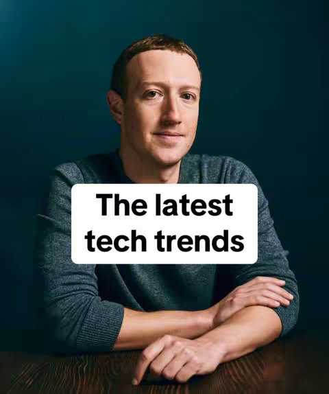 A studio portrait of Mark Zuckerberg. He is seated, his arms crossed over a wooden table. He is wearing a gray long sleeve shirt. A white rectangle with black text is overlaid on the image.