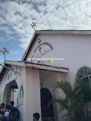 The image showcases a white building with a pointed roof and a cross-shaped decoration at the top. The text "ORTHODOX PATRIARCHATE" is visible. People are gathered outside. Additional text overlays include "day 3 of my mission trip in kenya".