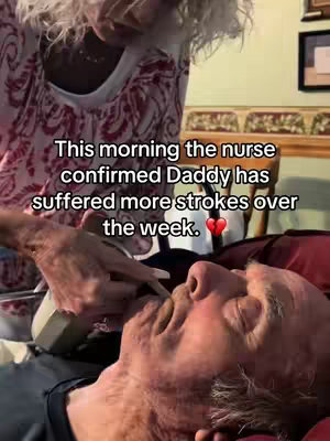 The cover image shows an elderly man lying in bed, seemingly ill, with a woman standing over him. The woman is wearing a patterned top and appears to be attending to the man. The scene is indoors, with a glimpse of a room setting in the background. The overall tone is somber and suggests a moment of caregiving.