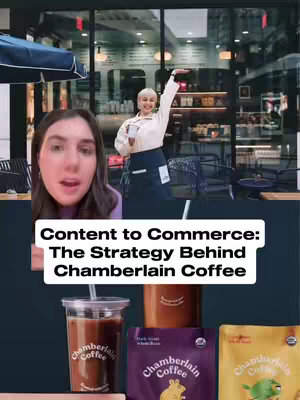 The cover image is a vertical composition that shows a split layout. The foreground features a woman with brown hair, her face close and expressing. She is in the foreground, slightly off-center to the left, with her mouth open and her attention directed forward. Behind her and to the upper right, a woman in a white shirt and a black apron gestures in a coffee shop. A variety of coffee products are arranged in the bottom center, including a coffee cup with a straw, a cylindrical container, and three different coffee bags with the brand name.
The text overlay at the bottom center of the image reads, 'Content to Commerce: The Strategy Behind Chamberlain Coffee,' written in a clean, white font against a black background.