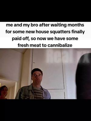 The image shows a scene from a movie or TV show, likely a horror or dark comedy. The main focus is on a man in the foreground, wearing a striped shirt and jacket, with a concerned or surprised expression. Behind him, another person is partially visible. The background appears to be a home interior, with a door and a wall visible. The color palette is muted, and the lighting is dim which creates a sense of tension or foreboding.