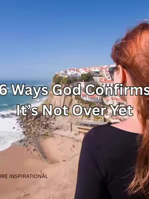 A woman with red hair is seen from the back looking towards a scenic coastal view. Text overlayed on the image reads "6 Ways God Confirms It’s Not Over Yet". In the background, there are white buildings on a cliffside with the ocean and clear blue sky.