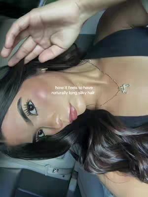 The cover image shows a young woman, seen from the chest up, gazing slightly upwards. She is positioned at an angle, with her face and hair taking up most of the frame. Her dark hair cascades around her face. She wears makeup, and a necklace featuring a pendant. The background is indistinct and out of focus.