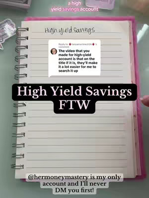 An overhead shot of a pink spiral notebook open on a desk.  The page is filled with handwritten notes.  A screenshot of a comment box with a user's comment on the video is near the top. Text overlays include "a high yield savings account" and "High Yield Savings FTW".