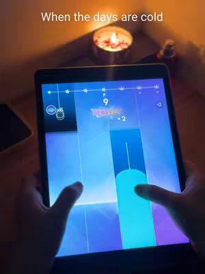 The cover image shows a tablet displaying a music game, with hands interacting with the screen. A lit candle and a dark smartphone are on the table in the background. The scene has low lighting and a warm color palette from the candle.