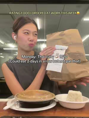 A woman is shown in a well-lit office setting, holding a brown paper bag with a clear plastic container and a white bowl with a rice dumpling on the table. She's smiling, holding the food items from UberEats. Text overlays display the food rating.