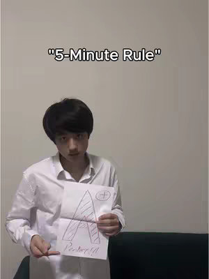 A young man stands in front of a neutral background, holding a drawing of a large letter "A" that is labeled as "Perfect!!!" and featuring drawing elements in red. Text overlay "5-Minute Rule" is displayed at the top of the image.