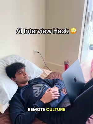A young man is lying in bed with a laptop on his legs. Text overlays read: 'AI Interview Hack' and 'Remote Culture'.