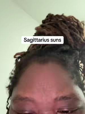The cover image features a close-up shot of a person's face, focusing on the forehead and upper eyes. The person has dark, curly hair and appears to be of African descent. The background is a plain, light color, and a text overlay above the person's head reads "Sagittarius suns".