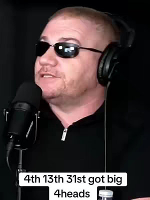 A man with sunglasses, a microphone, and headphones, appears to be in a recording session.