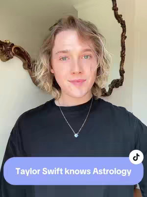 A portrait-style shot of a young man with light skin, blond hair, and blue-green eyes. He's wearing a black shirt and a silver necklace with a small pendant. The background includes a decorative mirror. A text overlay at the bottom of the image says, "Taylor Swift knows Astrology."