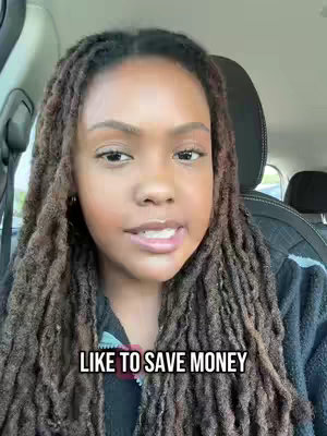 A woman with long, textured hair sits inside a car, with text overlayed. The framing is a medium shot, focusing on her face and upper body. She appears to be talking, and the lighting suggests it might be indoors.