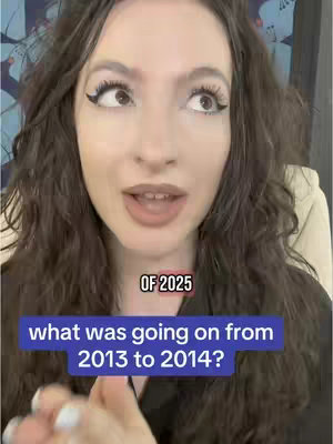 A woman with long brown hair looks directly at the camera, speaking. Text overlays appear on the image. The background appears to be blurred decorated wall.