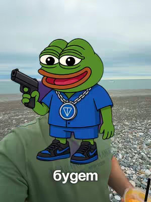 The cover image features a selfie-style shot with a green cartoon frog holding a handgun. The background is a beach scene with the ocean. The frog wears a blue shirt, blue shorts, and black sneakers. Text overlay "будет" at the bottom of the image and is shown at the neck of a person wearing a green shirt that holds a cold beverage.