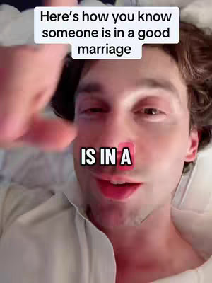 A selfie-style shot featuring a man lying in what appears to be a bed. Above his head is a white rectangular box in which the text is written in a black, bold font. His face fills most of the frame, and he is looking directly into the camera. Below the top text overlay is another text overlay. The background is soft and out of focus with colors suggesting possibly a white or lightly colored bed sheet.