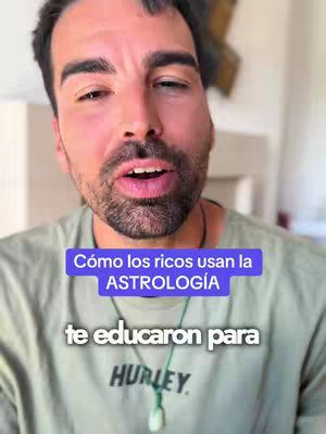 A mid-shot of a man with short dark hair and a beard, looking directly at the camera, with text overlays in the image. He is wearing a green t-shirt, and a necklace. The background is blurry.