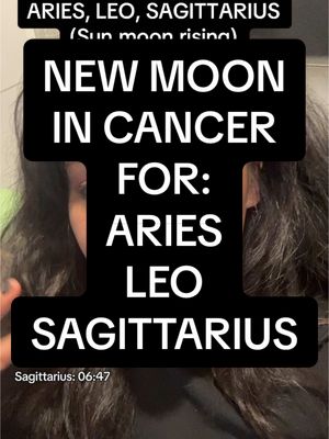 The cover image features a woman's face partially visible, overlaid with a black rectangular box containing white text. The text announces "NEW MOON IN CANCER" and further specifies the content is "FOR: ARIES LEO SAGITTARIUS." Additional text above indicates it is about Sun, Moon, and Rising signs. The image is framed with medium lighting, and the woman’s dark hair frames her face.