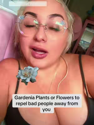 The cover image is a selfie of a woman with blonde hair and glasses, looking towards the camera with a natural expression. Text overlaid on the image reads "Gardenia Plants or Flowers to repel bad people away from you." A blue floral graphic is placed beneath her face.