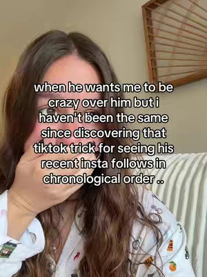 A selfie-style shot focuses on a woman. The woman has long brown hair and is wearing a top. She is covering her mouth with her hand. The image has text overlayed on the top.