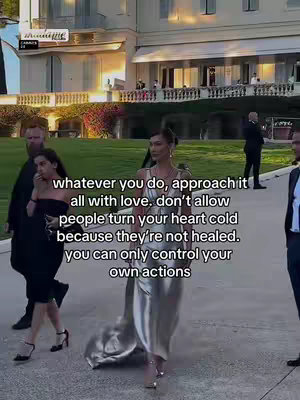 A woman in a silver dress is walking on a paved surface with people in the background. Text overlayed on top of image.
