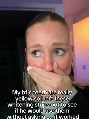 A woman is shown close up, with her hand covering her mouth in a gesture of surprise or shock. Her eyes are wide, and she appears to be looking off to the side with a concerned expression. Soft, natural light illuminates her face, and the background is blurred.