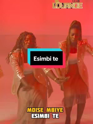 Two women in sparkly outfits are shown in a red-toned setting. The main subject is the women in front of a teal/blue box with text. The top right corner has a logo in gold lettering.