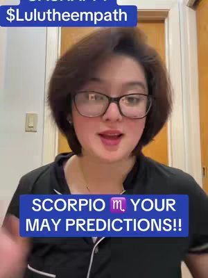 A woman with short dark hair and glasses is centered in the frame, speaking with an open mouth. A dark blue banner at the bottom contains white text against a purple zodiac symbol.