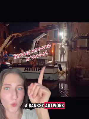 A woman with fair skin presents a video with a dark background as a boat is shown with an artwork behind it. The woman points towards the screen, with overlaid text. The image has a focus on the subject's face and a street scene.