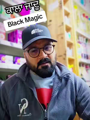 A man with a beard and glasses wearing a black cap and gray jacket is framed from the chest up. Text overlays in both English and a non-English script are positioned above the man's head. The background consists of shelves with products.