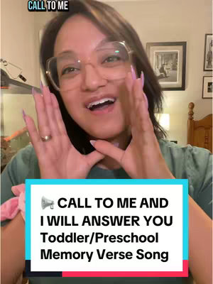The cover image is a selfie-style shot of a woman centered against a softer background possibly an interior. The woman has fair skin, dark hair with some lighter highlights, and is wearing large framed glasses and a top. She is positioned with her hands up near her face, palms facing the viewer. The text overlay is in a rectangular box with the caption written in white font on top of a background of aqua. Additional text at the very top of the image identifies the text as a verse from the bible.