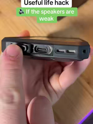 The cover image shows a close-up of a hand holding a black mobile phone, with the phone's speaker visible. Text overlays provide a life hack, suggesting speaker cleaning.