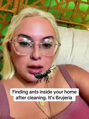 The cover image features a woman with blonde hair and glasses, sitting in a wicker chair against a green background. She is wearing a mauve top and several necklaces. An animated ant is superimposed near her chest. Text at the bottom reads, "Finding ants inside your home after cleaning. It's Brujeria".