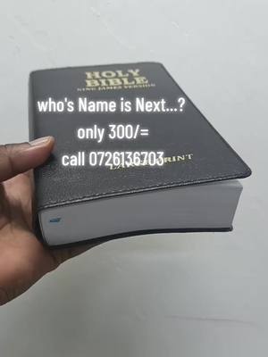 A person's hand is holding a black Bible open to display some text. The cover of the Bible has the text 'HOLY BIBLE' in gold lettering. White text overlays the Bible with the questions 'who's Name is Next...?' along with the price and phone number. The background is a light neutral color.