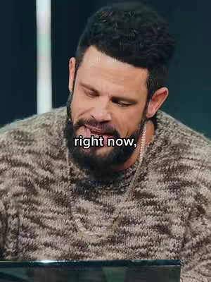 A man with a beard and a sweater is looking down slightly to his left. Overlayed text reads "right now," in the bottom center of the screen.