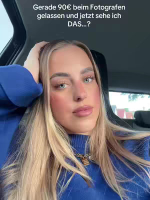 A selfie-style shot taken from inside a car. A young woman with long blonde hair and blue eyes takes up most of the frame. Her skin is fair with visible makeup, including blush. She’s wearing a blue sweater and has her hand resting on her head. Text overlaid at the top of the image reads: “Gerade 90€ beim Fotografen gelassen und jetzt sehe ich DAS…?”