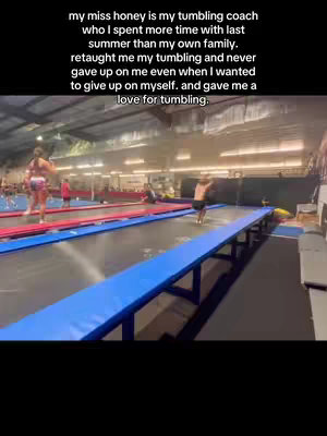 A video from a gymnastics facility, showing a girl doing a flip on a trampoline. The shot is taken at a medium distance.
